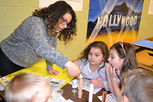 Lina Florez works with young children during Cena y Ciencias.