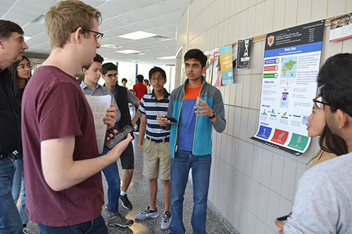 Joe Muskin and Christopher Aksland watch as a Uni High student gives his team's presentation.