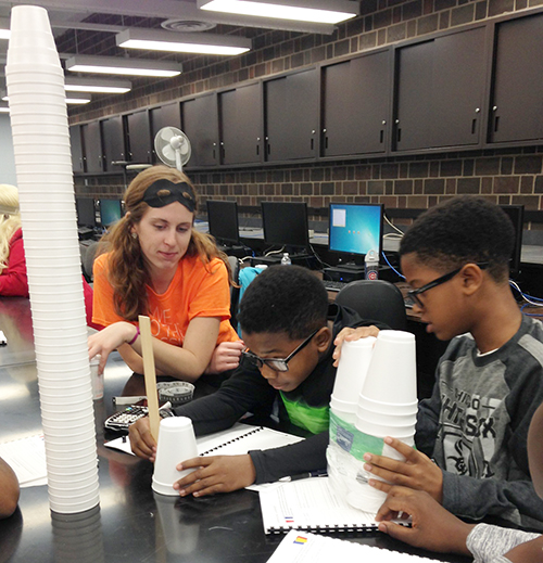  <em>Illinois</em> Engineering student Emily Matijevich (left) supervises while two Chicago students do a hands-on activity during one of the Fall 2015 ChiS&E workshops at UIC. (photo by Sahid Rosado) 
