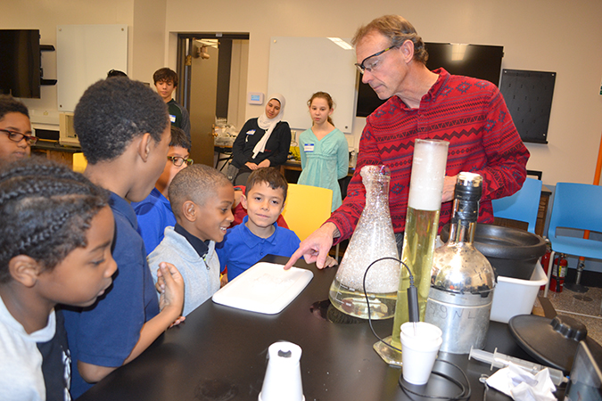 David Bergandine (right) teaches local boys about science during his liquid nitrogen activity, part of Uni-DREAAM Connect after-school activities on December 12th.