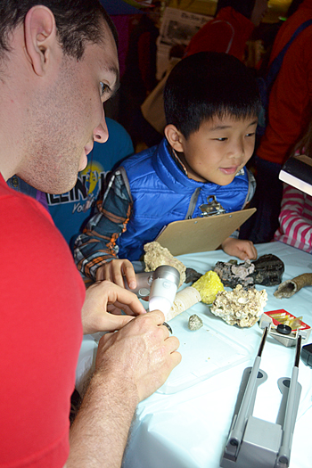Jim Bruce supervises while a local youngster uses the ProScope to magnify rocks and coral.